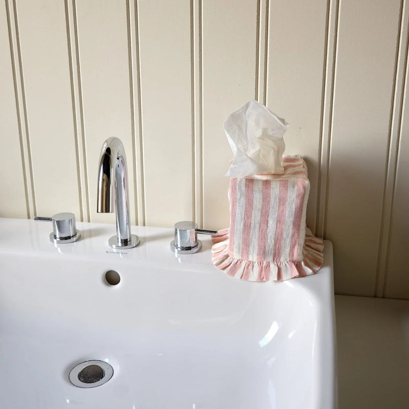 Bathroom sink with a pink and cream tissue cover and box