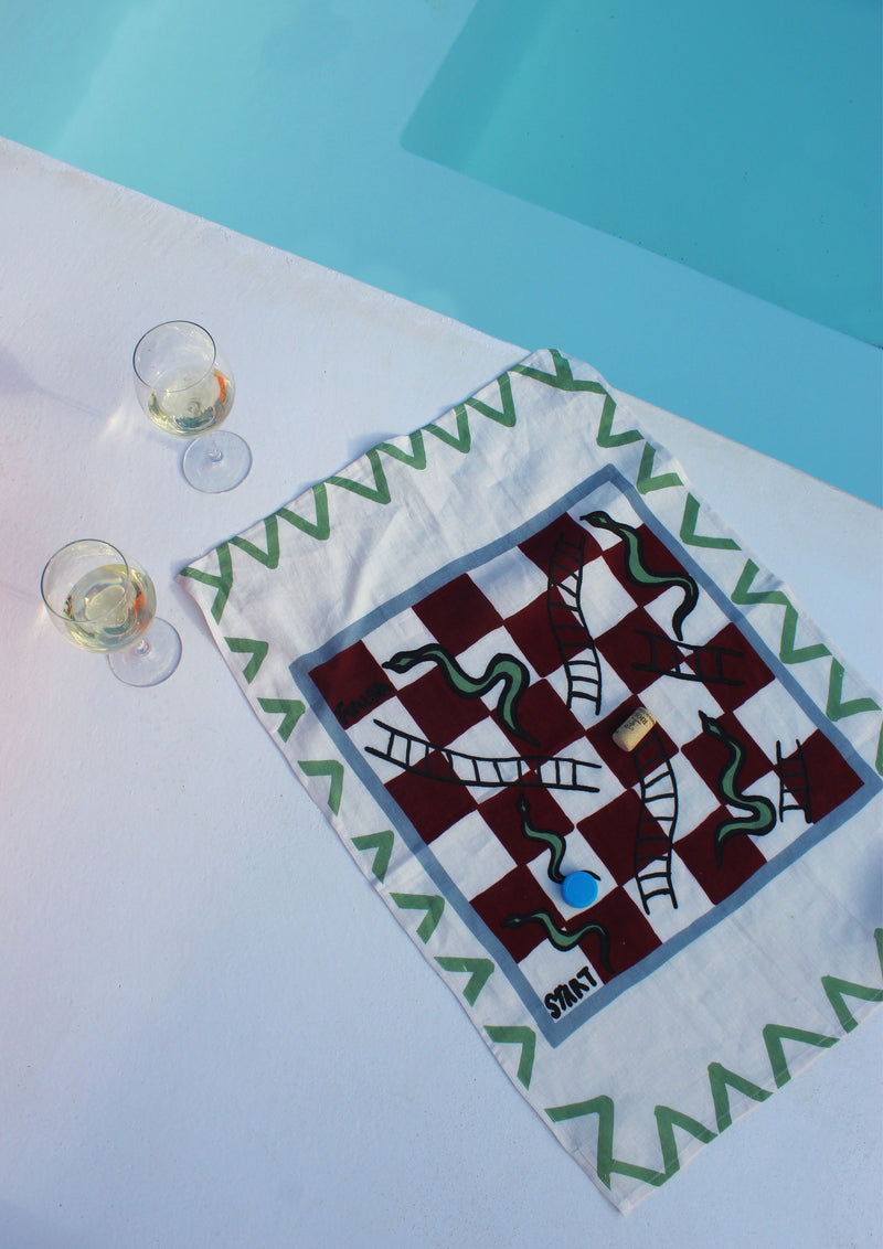 Gammon tea towel game being used with gammon pieces